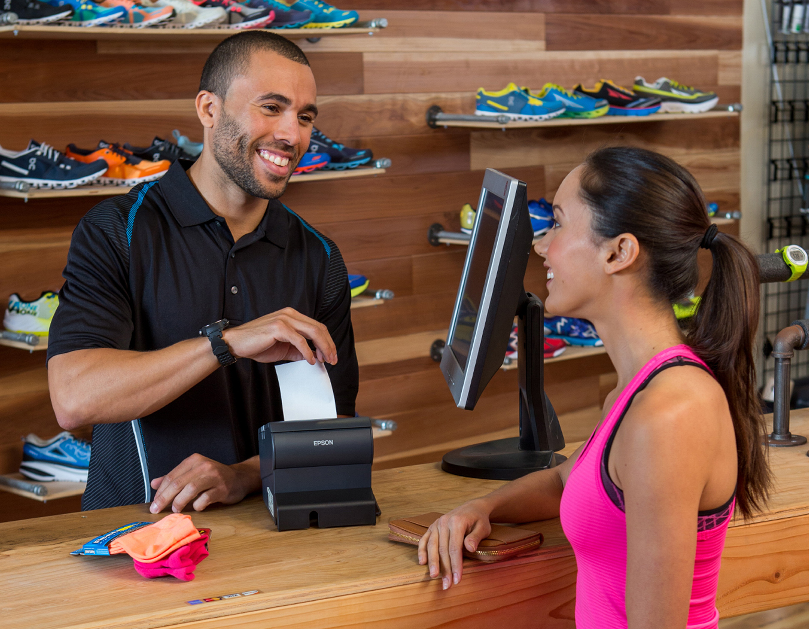 Cashier giving woman a receipt in a shoe store