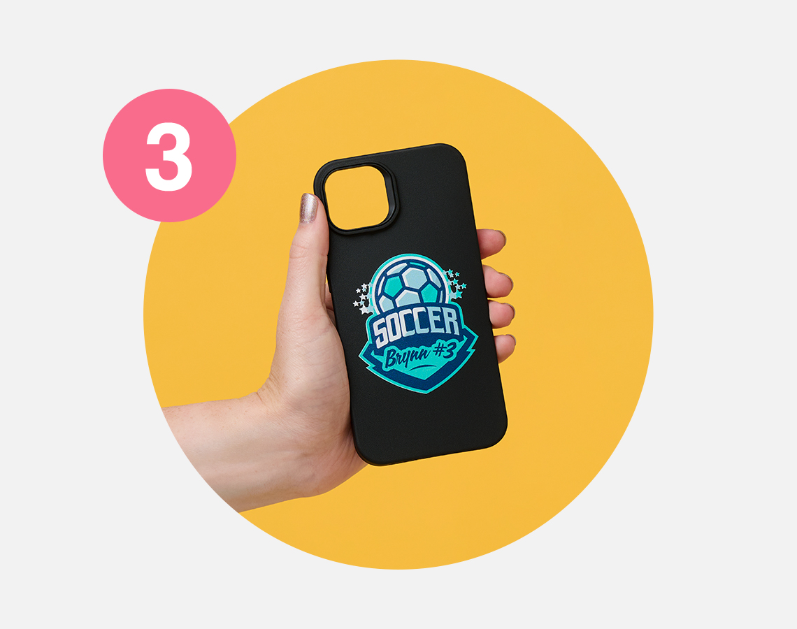 A hand holding a phone case with a soccer ball design.