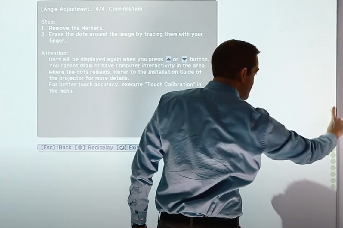 A business person in front of a projected screen
