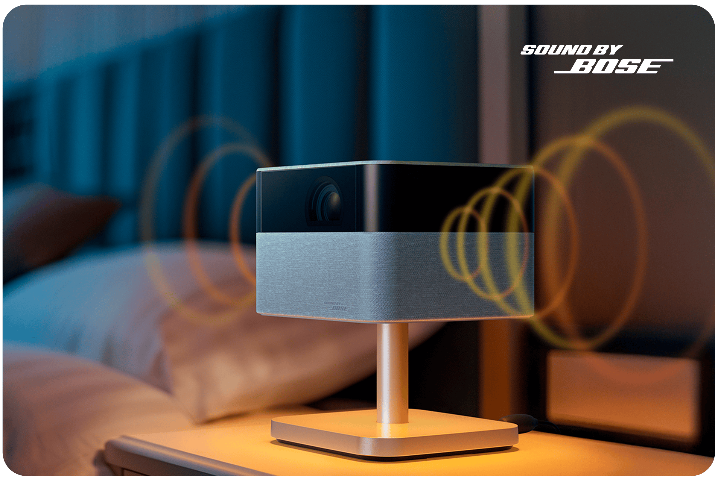 Sound by Bose | A projector on a bedside table, with sound waves emanating from the sides
