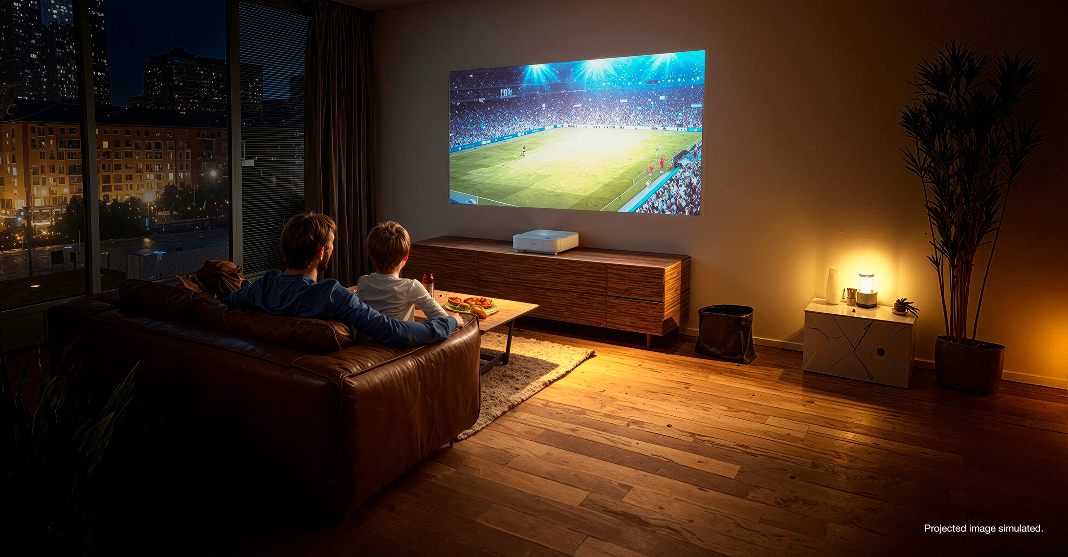 Father and son watching a soccer game on a projected screen. Project image simulated.