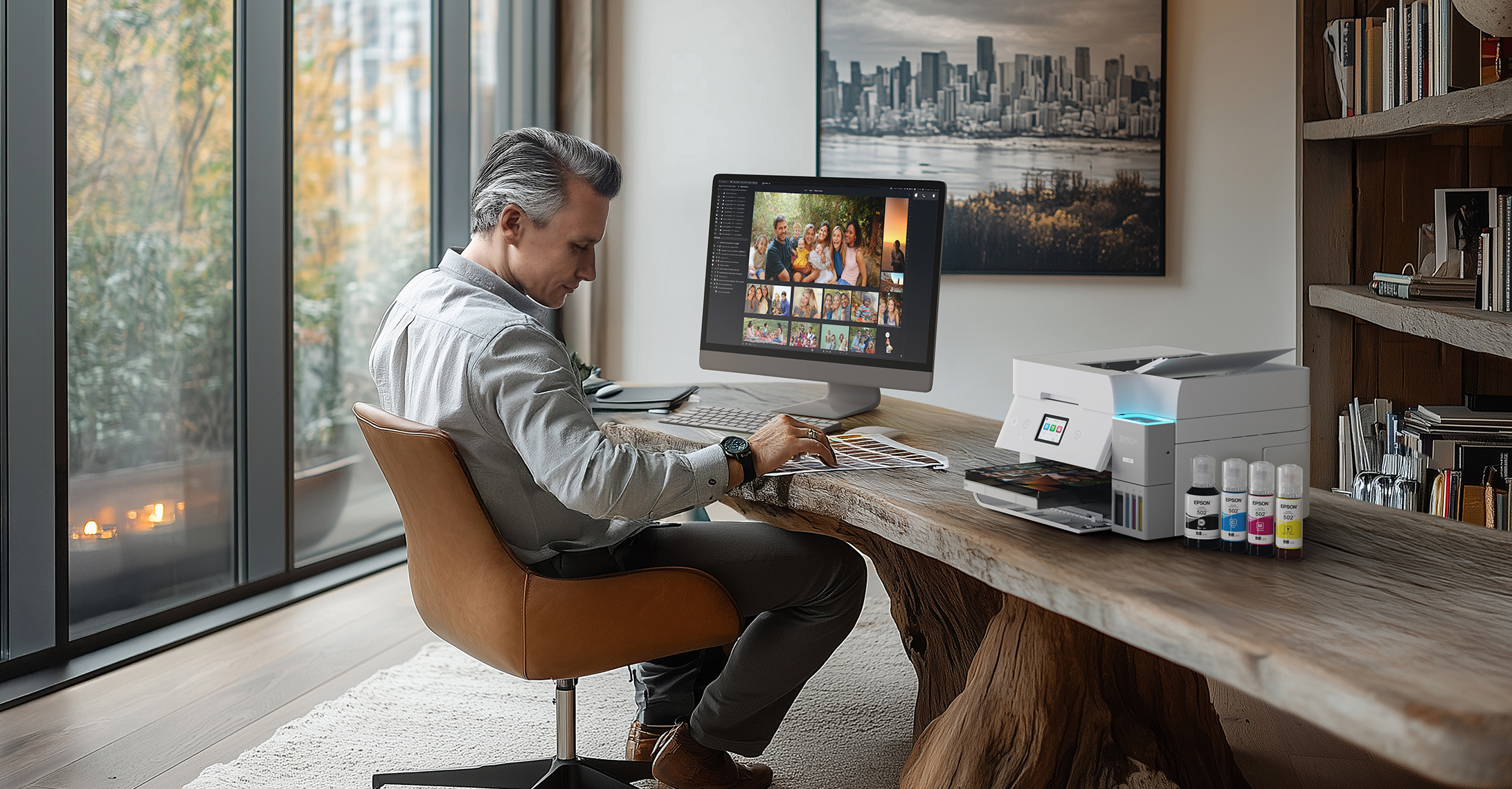  Man working in a modern home office, seated at a desk with a computer and EcoTank printer.