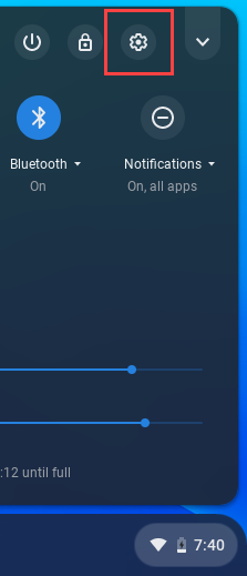 The settings icon highlighted over the Chromebook shelf of the desktop.