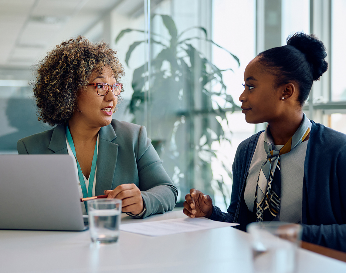 Two school administrators discussing financial documents in an office.