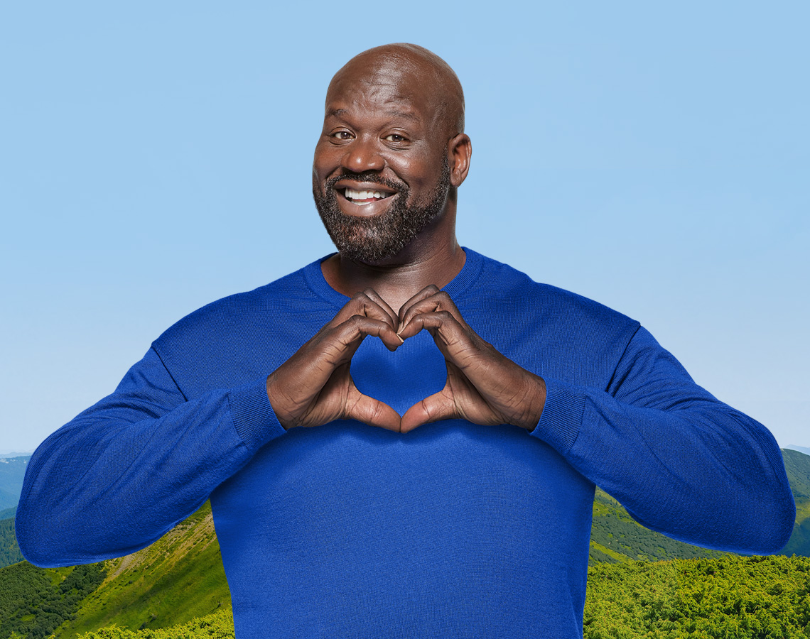 Shaq showing his love for the environment against a backdrop of a pristine valley