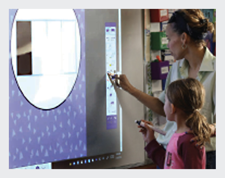 A teacher helping a student interact with a projected image