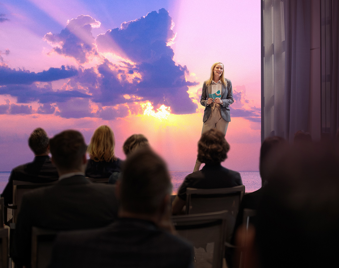 Woman giving speechin front of projected image.