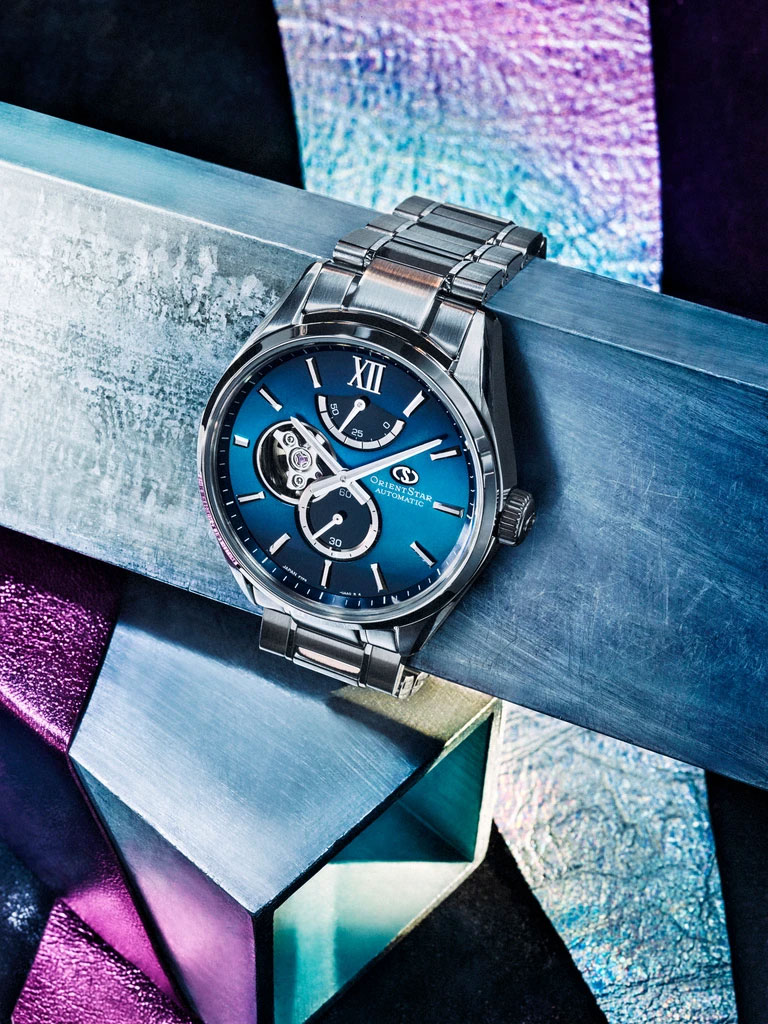 A medium crop of the M34 F7 Semi Skeleton watch on a metallic backdrop of blues and purples