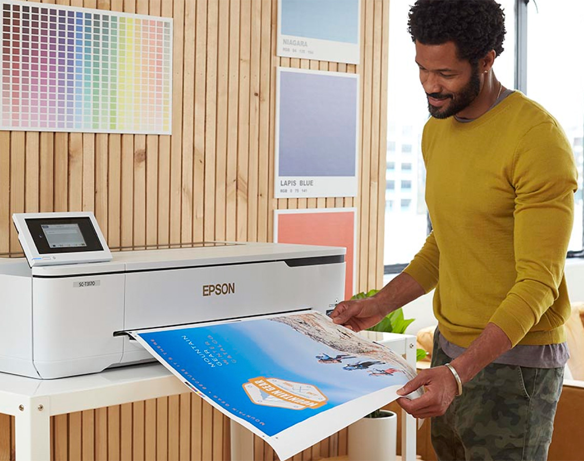 Man looking at output from a large format printer