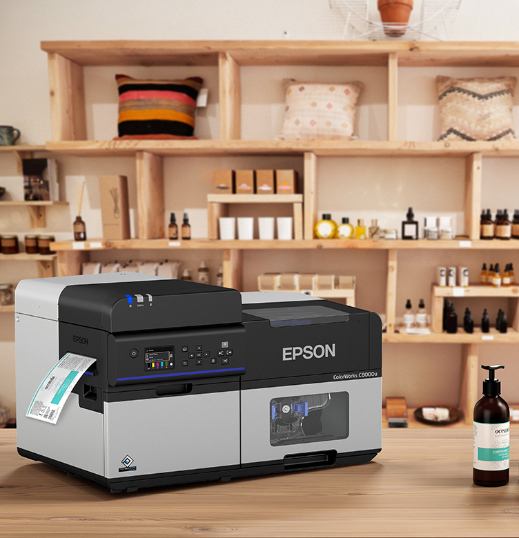 An Epson ColorWorks C8000 printer on a retail store countertop printing shampoo bottle labels.