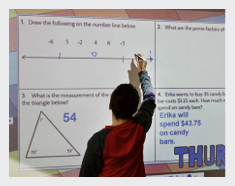 A student interacting with a projected image on a white board