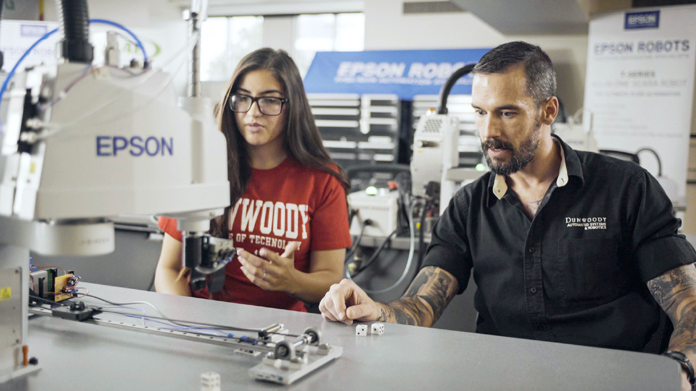 College students observing an Epson robot 