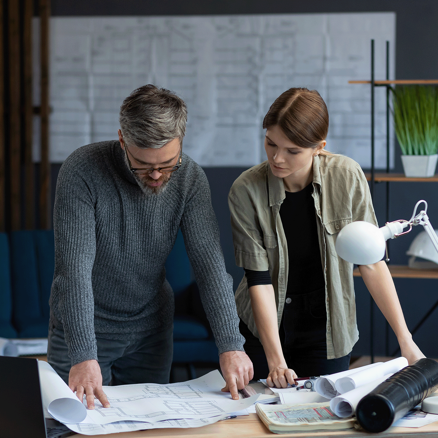 Two professionals look over plans on paper