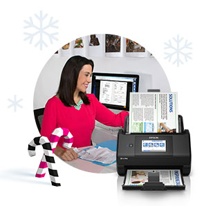 A woman at a desk inserting receipts into a scanner.