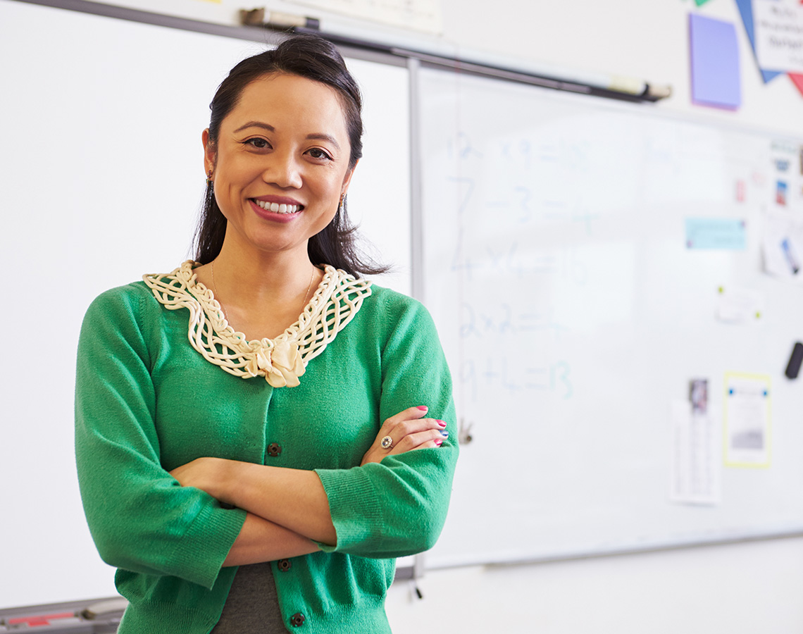 A teacher standing in front of a whiteboard.