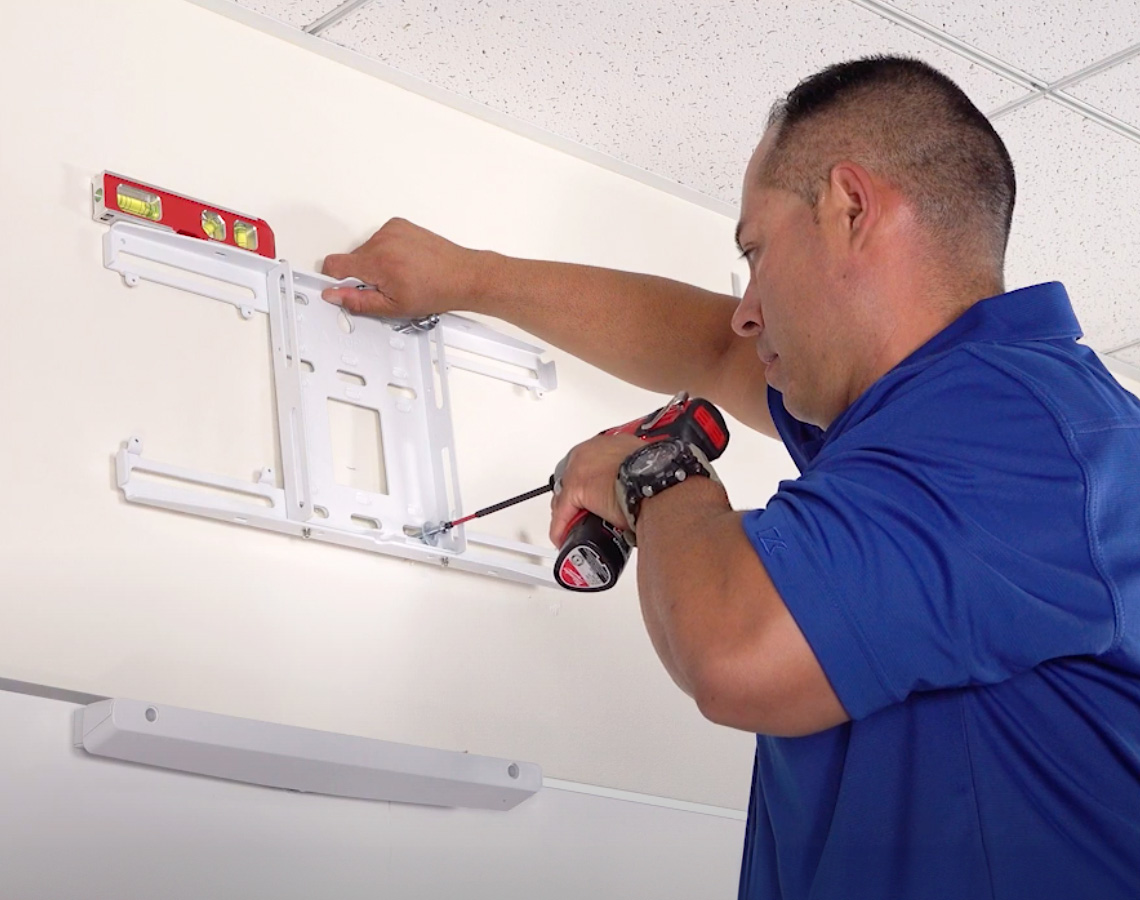 Man installing a projector mount