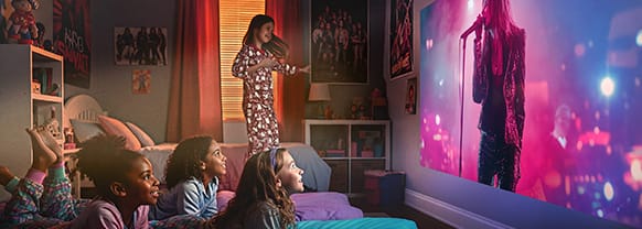 A group of children enjoy a concert on a projected output
