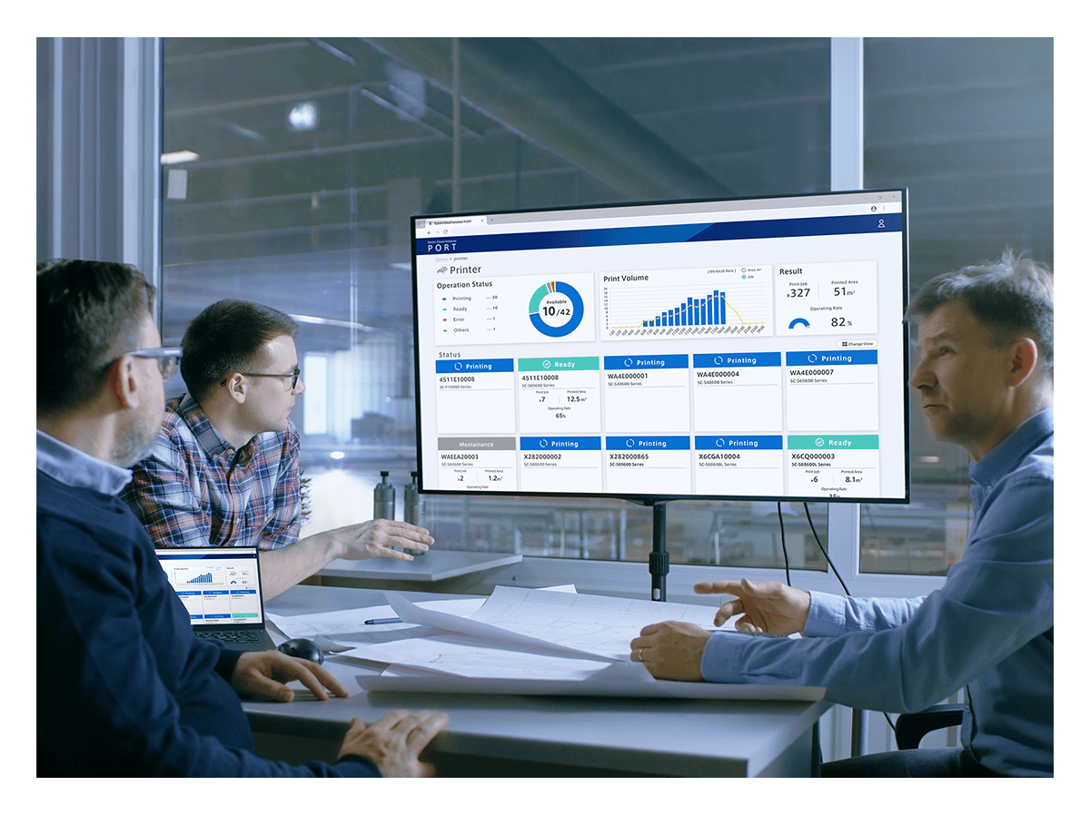 A group of people sitting around a computer screen reviewing optimization metrics.