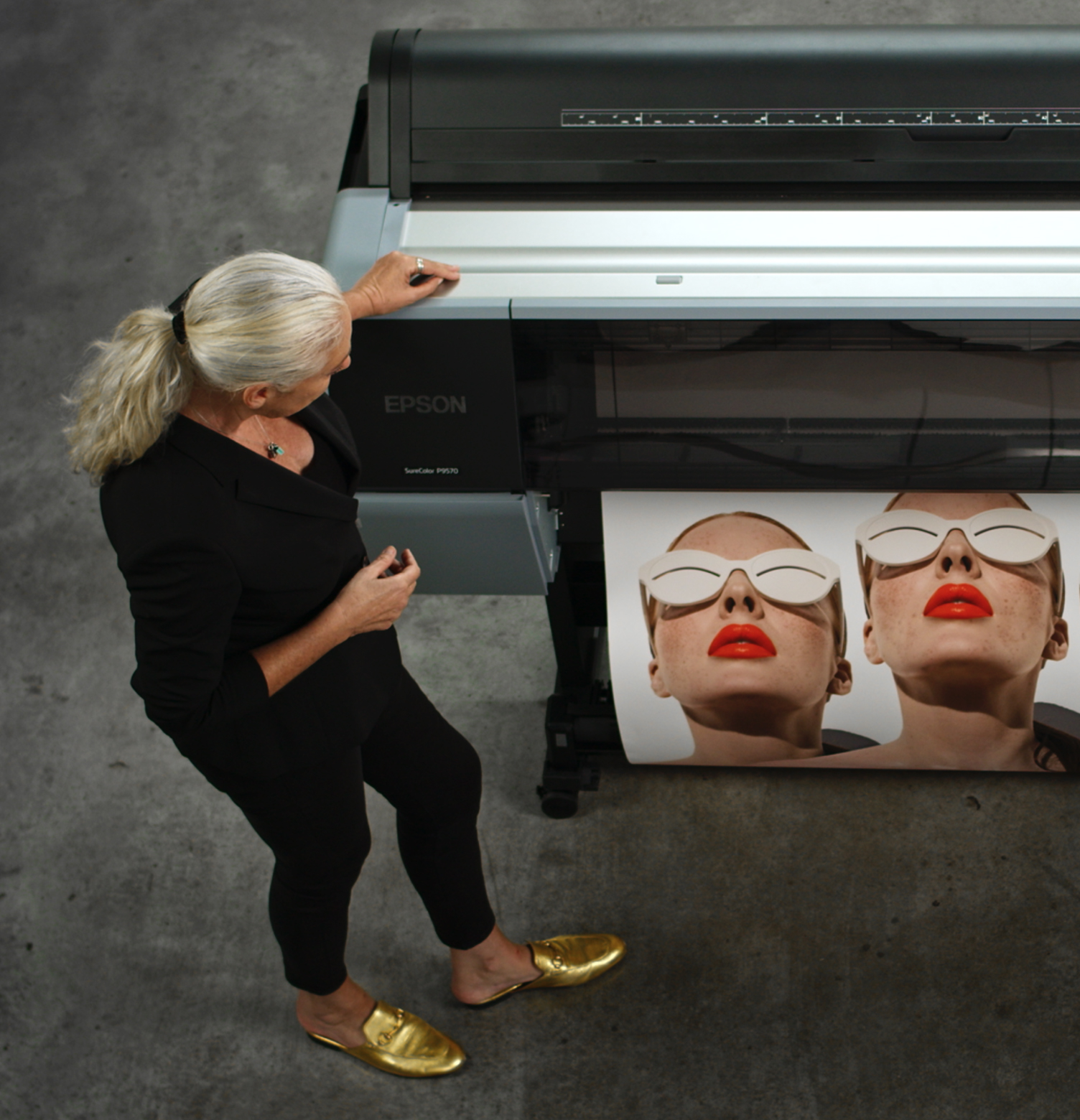 Two people stand in a gallery viewing Edward Burtynsky prints.