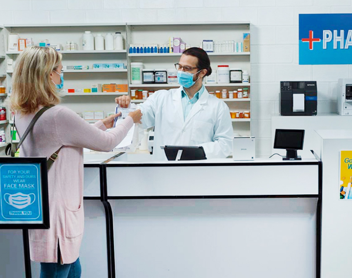 Person picking up prescription from pharmacist
