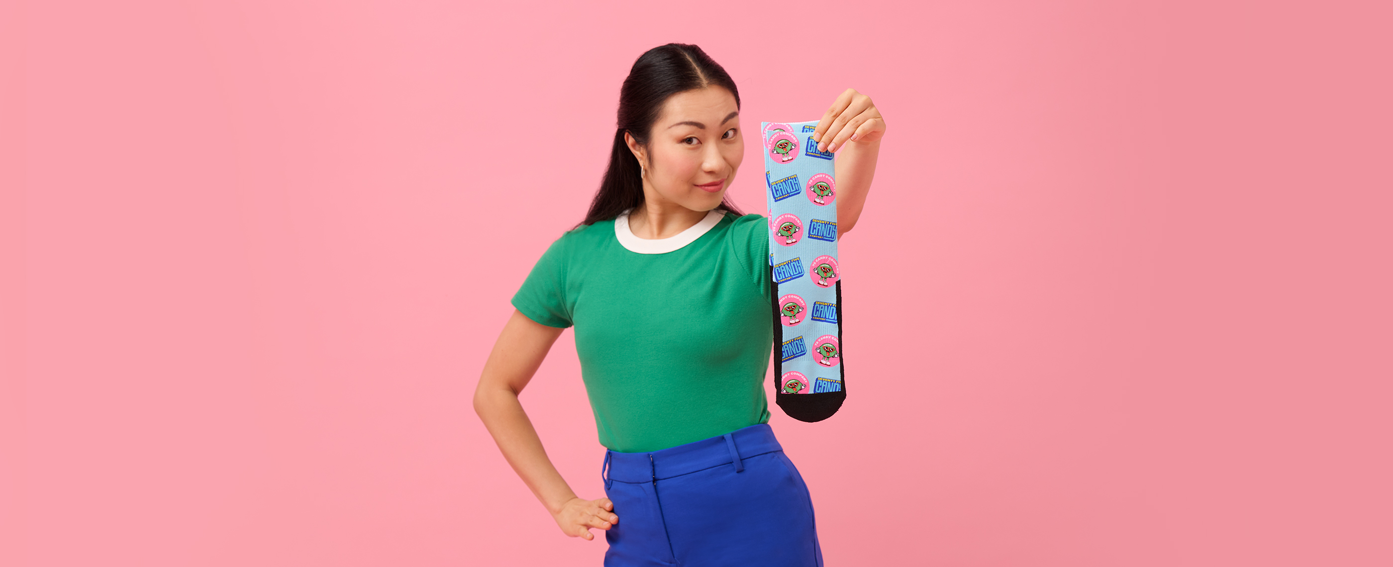 Socks printed with candy designs held by a smiling woman.